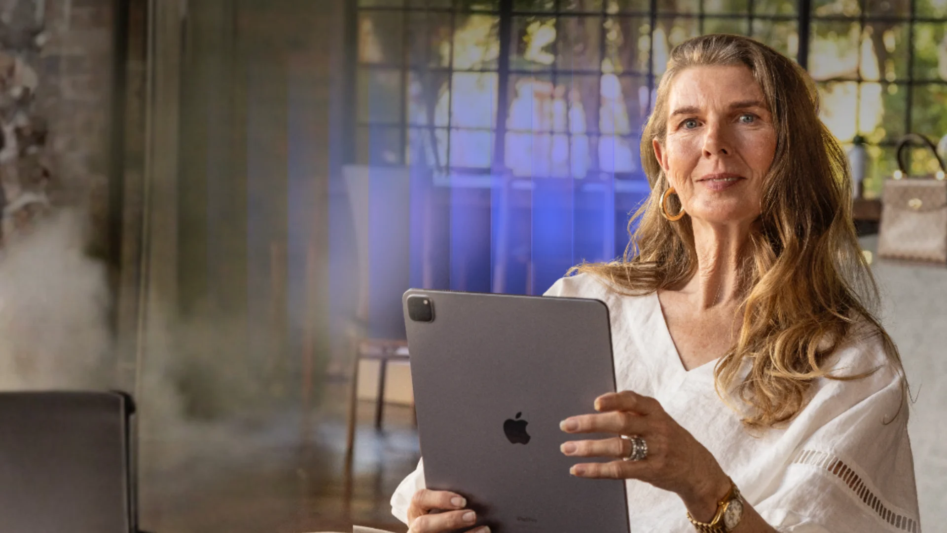 Woman holding a tablet while seated in a modern home interior